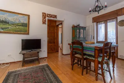 a dining room with a table and a television at El Barance-Boscoverde 2 in Sottoguda