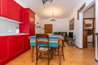 a kitchen with red cabinets and a table with chairs at El Barance-Boscoverde 2 in Sottoguda