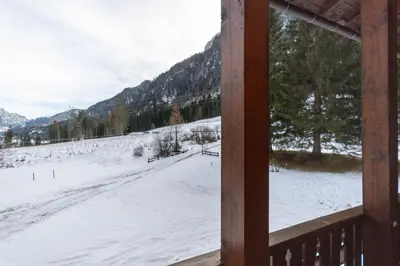 a view of a snow covered field from a cabin window at El Barance-Boscoverde 2 in Sottoguda