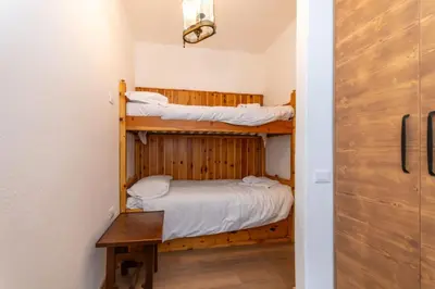 a room with two bunk beds and a door at El Mugo-Boscoverde 1 in Sottoguda