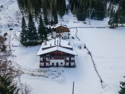 an aerial view of a house covered in snow at El Mugo-Boscoverde 1 in Sottoguda