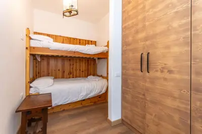a bedroom with two bunk beds and a door at El Mugo-Boscoverde 1 in Sottoguda
