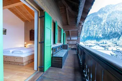 a balcony of a house with a bed and a mountain at Cesa Lalla in Campitello di Fassa