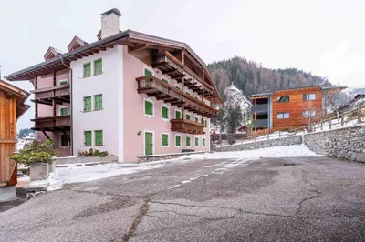a building in the middle of a parking lot at Cesa Lalla in Campitello di Fassa