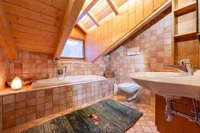 a bathroom with a sink and a tub and a toilet at Cesa Lalla in Campitello di Fassa