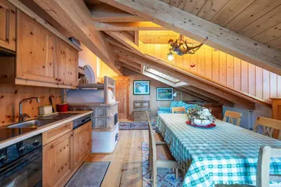 a kitchen with wooden cabinets and a table in a cabin at Cesa Lalla in Campitello di Fassa