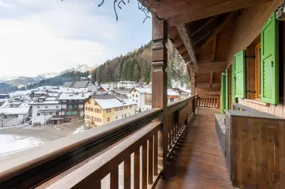 a balcony of a building with a view of a town at Cesa Lalla in Campitello di Fassa