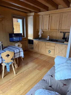 a kitchen with wooden cabinets and a table in a room at Precumon 8'1 in Arabba