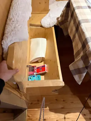 a wooden box with toys in it next to a bed at Precumon 8'1 in Arabba