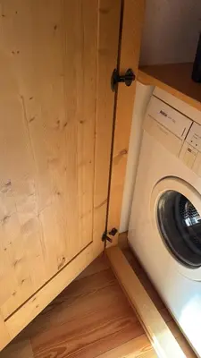 a washing machine sitting next to a wooden cabinet at Precumon 8'1 in Arabba