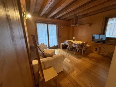 a living room with a table and a dining room at Precumon 8'1 in Arabba