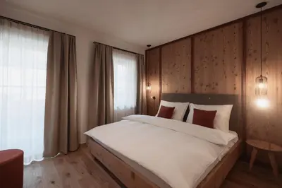 a bedroom with a large bed with a wooden wall at Aberle Hof in Rasùn di Sotto