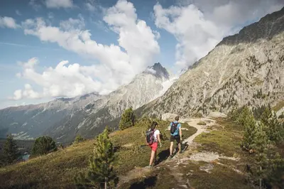 a couple of people walking on a mountain trail at Aberle Hof in Rasùn di Sotto