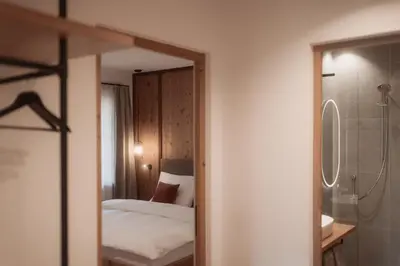 a bedroom with a bed and a shower and a mirror at Aberle Hof in Rasùn di Sotto