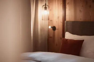 a bedroom with a bed with a light on the wall at Aberle Hof in Rasùn di Sotto