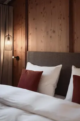a bedroom with a bed with white sheets and red pillows at Aberle Hof in Rasùn di Sotto
