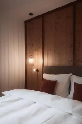 a bedroom with a bed with white sheets and pillows at Aberle Hof in Rasùn di Sotto