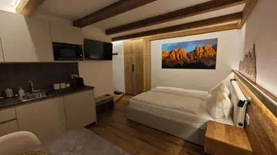a hotel room with a bed and a sink at Il Laricino in Predazzo