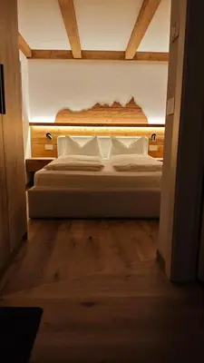 a bedroom with a large bed with white pillows at Il Laricino in Predazzo