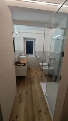 a bathroom with two sinks and a toilet and a mirror at Il Laricino in Predazzo