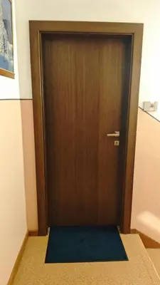 a wooden door with a mat in front of it at Il Laricino in Predazzo