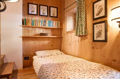 a bedroom with a bed in a room with wooden walls at Dimora Nobile d'Ottocento - parcheggio interno in Cortina dʼAmpezzo