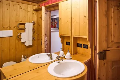 a bathroom with a sink in a wooden cabin at Dimora Nobile d'Ottocento - parcheggio interno in Cortina dʼAmpezzo