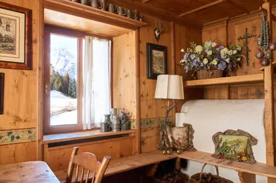a wooden room with a table and a window at Dimora Nobile d'Ottocento - parcheggio interno in Cortina dʼAmpezzo