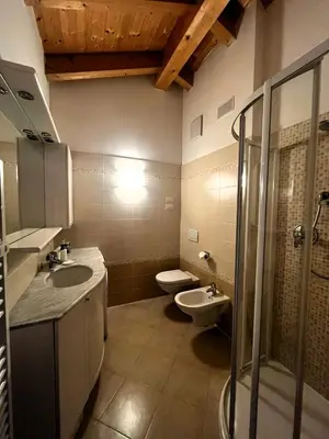 a bathroom with two sinks and a toilet and a shower at Cèsa Nicole e Patrick in Campitello di Fassa