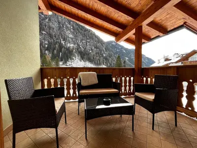 a balcony with chairs and a table with a mountain view at Cèsa Nicole e Patrick in Campitello di Fassa