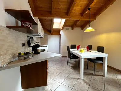 a kitchen with a white table and chairs in a room at Cèsa Nicole e Patrick in Campitello di Fassa