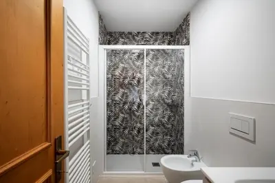 a bathroom with a shower curtain and a sink at Happiness 14 in Castello di Fiemme