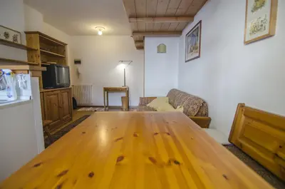 a living room with a wooden table and a couch at Cortina da vivere il tuo rifugio a due passi da tutto in Cortina dʼAmpezzo