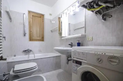 a bathroom with a washing machine and a sink at Cortina da vivere il tuo rifugio a due passi da tutto in Cortina dʼAmpezzo
