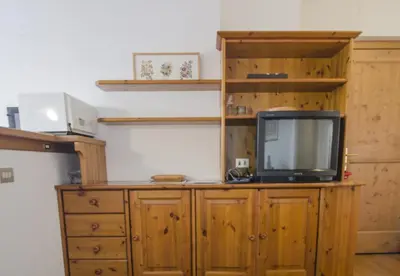 a tv sitting on top of a wooden cabinet at Cortina da vivere il tuo rifugio a due passi da tutto in Cortina dʼAmpezzo
