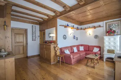 a living room with a red couch and a table at La tua coccola a Cortina in Cortina dʼAmpezzo