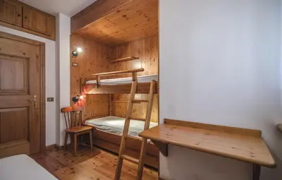 a small room with a bunk bed and a desk at La tua coccola a Cortina in Cortina dʼAmpezzo