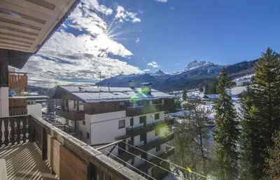 a balcony of a building with a view of the mountains at La tua coccola a Cortina in Cortina dʼAmpezzo