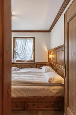 a bedroom with a large bed with a window at Casa Lana, comfort nel centro di Cortina d Ampezzo in Cortina dʼAmpezzo