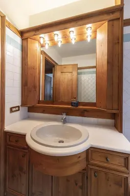 a bathroom with a sink and a mirror at Casa Lana, comfort nel centro di Cortina d Ampezzo in Cortina dʼAmpezzo