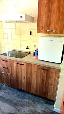 a kitchen with wooden cabinets and a counter top at Luminoso e centralissimo attico, splendida vista panoramica sulle Dolomiti e sulle piste olimpiche in Cortina dʼAmpezzo