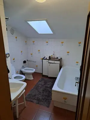 a bathroom with a tub and a toilet and a sink at Luminoso e centralissimo attico, splendida vista panoramica sulle Dolomiti e sulle piste olimpiche in Cortina dʼAmpezzo
