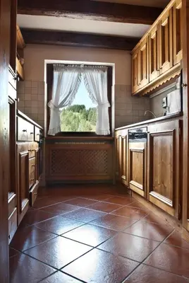 a kitchen with a window and a tiled floor at Classy typical apartment in Alvera' in Cortina dʼAmpezzo