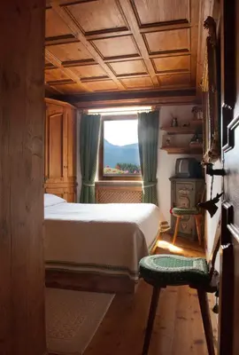 a bedroom with a bed and a window at Classy typical apartment in Alvera' in Cortina dʼAmpezzo