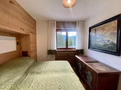 a bedroom with a bed and a window at Charming ground floor flat with breathtaking views in Cortina dʼAmpezzo