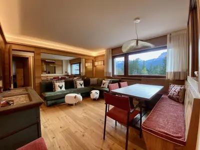 a living room with a couch and a table at Charming ground floor flat with breathtaking views in Cortina dʼAmpezzo
