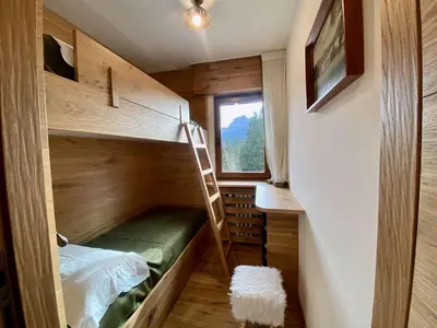 a small room with a bunk bed and a ladder at Charming ground floor flat with breathtaking views in Cortina dʼAmpezzo