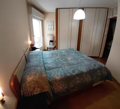 a bedroom with a bed with a blue comforter at Appartamento IN CENTRO a Predazzo in Predazzo