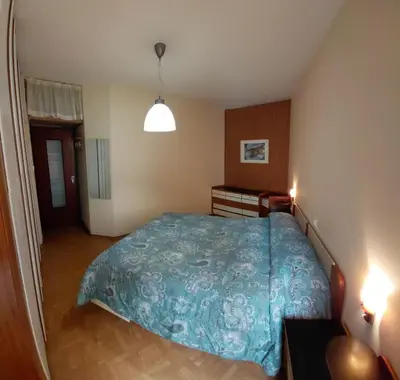 a bedroom with a bed with a blue comforter at Appartamento IN CENTRO a Predazzo in Predazzo