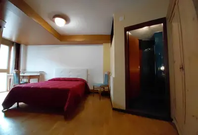 a bedroom with a bed with a red bedspread on it at Appartamento IN CENTRO a Predazzo in Predazzo